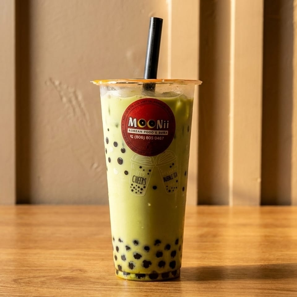 A Moonii Korean Food & Boba matcha bubble tea with tapioca pearls on a wooden table.